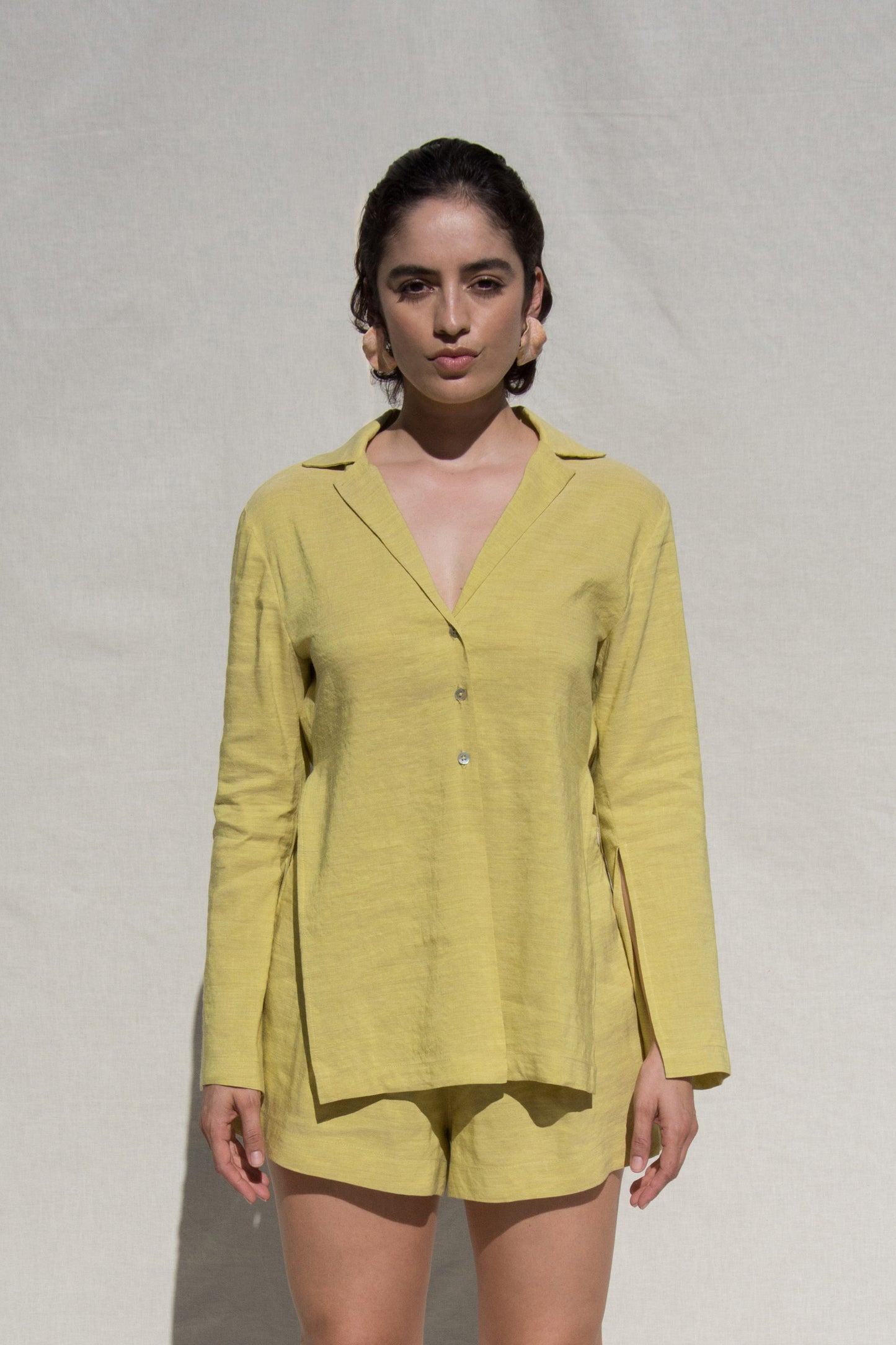 Front shot of model wearing long sleeve shirt and short set in Green Linen. Wearing Ceramic Pink earrings