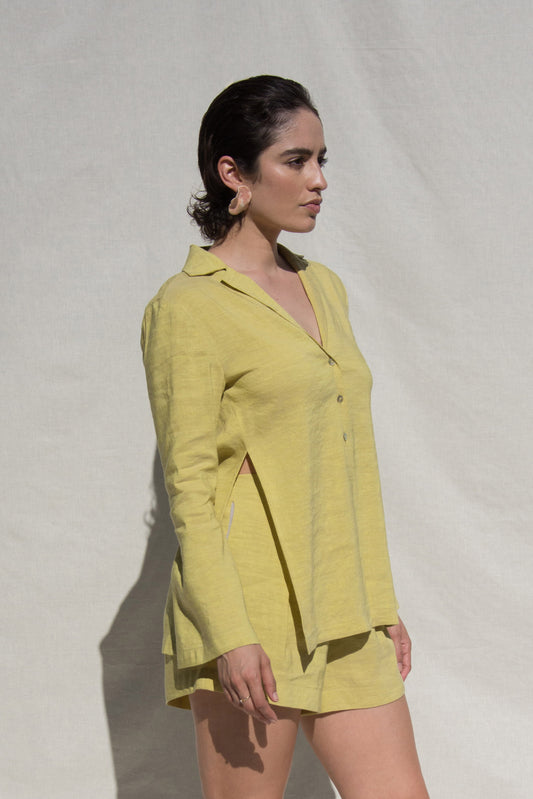 Side angle shot of model wearing long sleeve shirt and short set in green linen. Wearing Ceramic Pink earrings